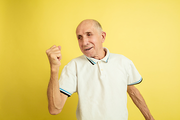 Image showing Caucasian senior man\'s portrait isolated on yellow studio background