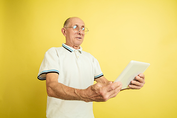 Image showing Caucasian senior man\'s portrait isolated on yellow studio background