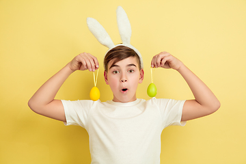 Image showing Easter bunny boy with bright emotions on yellow studio background