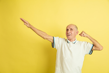 Image showing Caucasian senior man\'s portrait isolated on yellow studio background