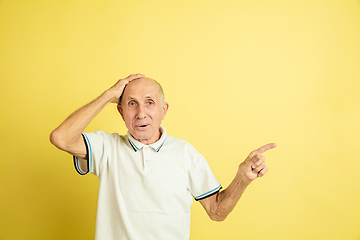 Image showing Caucasian senior man\'s portrait isolated on yellow studio background