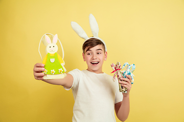 Image showing Easter bunny boy with bright emotions on yellow studio background