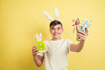 Image showing Easter bunny boy with bright emotions on yellow studio background