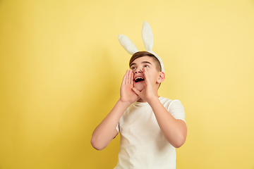 Image showing Easter bunny boy with bright emotions on yellow studio background