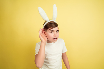 Image showing Easter bunny boy with bright emotions on yellow studio background