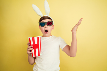 Image showing Easter bunny boy with bright emotions on yellow studio background