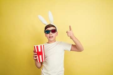 Image showing Easter bunny boy with bright emotions on yellow studio background