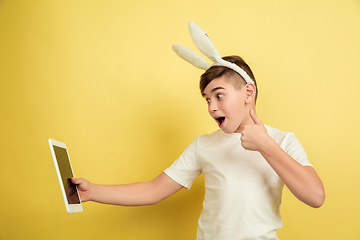 Image showing Easter bunny boy with bright emotions on yellow studio background