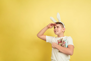 Image showing Easter bunny boy with bright emotions on yellow studio background