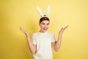 Image showing Easter bunny boy with bright emotions on yellow studio background