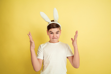 Image showing Easter bunny boy with bright emotions on yellow studio background