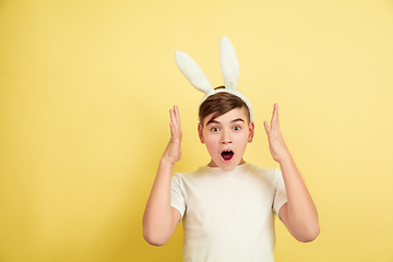 Image showing Easter bunny boy with bright emotions on yellow studio background