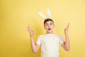 Image showing Easter bunny boy with bright emotions on yellow studio background