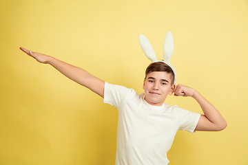 Image showing Easter bunny boy with bright emotions on yellow studio background