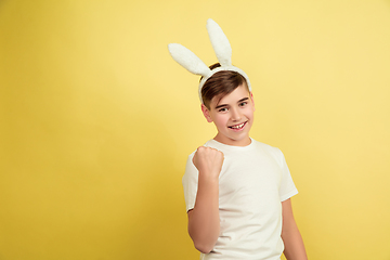 Image showing Easter bunny boy with bright emotions on yellow studio background