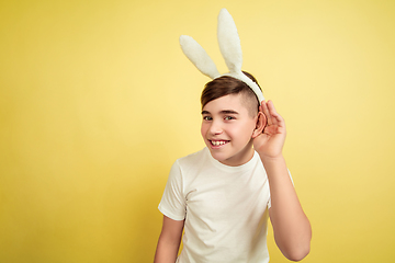 Image showing Easter bunny boy with bright emotions on yellow studio background