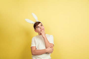 Image showing Easter bunny boy with bright emotions on yellow studio background