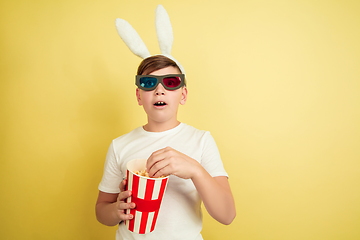 Image showing Easter bunny boy with bright emotions on yellow studio background