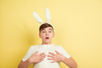 Image showing Easter bunny boy with bright emotions on yellow studio background