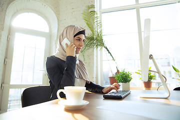 Image showing Portrait of a beautiful arabian businesswoman wearing hijab while working