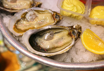 Image showing Close-up dish with fresh seafood, oysters with lemon and sauce o