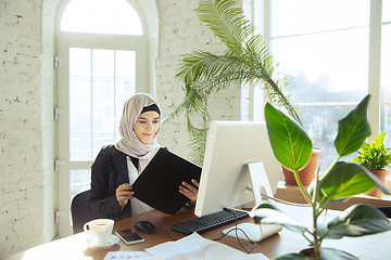 Image showing Portrait of a beautiful arabian businesswoman wearing hijab while working