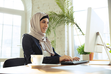 Image showing Portrait of a beautiful arabian businesswoman wearing hijab while working