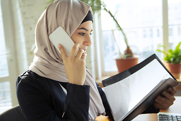 Image showing Portrait of a beautiful arabian businesswoman wearing hijab while working