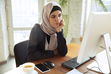 Image showing Portrait of a beautiful arabian businesswoman wearing hijab while working