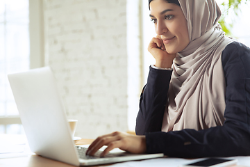 Image showing Portrait of a beautiful arabian businesswoman wearing hijab while working