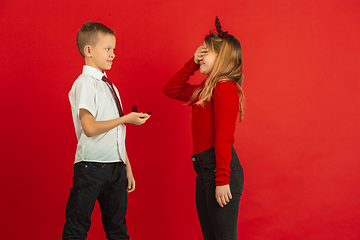 Image showing Valentine\'s day celebration, happy caucasian kids isolated on red background