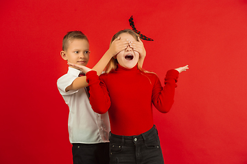 Image showing Valentine\'s day celebration, happy caucasian kids isolated on red background