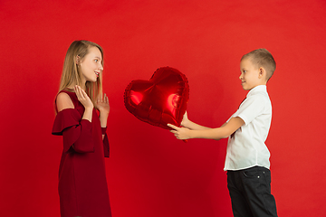 Image showing Valentine\'s day celebration, happy caucasian kids isolated on red background