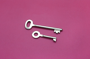 Image showing Metal keys close-up on bright crimson paper