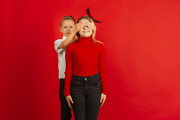 Image showing Valentine\'s day celebration, happy caucasian kids isolated on red background