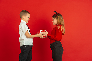 Image showing Valentine\'s day celebration, happy caucasian kids isolated on red background
