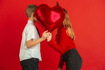 Image showing Valentine\'s day celebration, happy caucasian kids isolated on red background