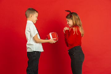 Image showing Valentine\'s day celebration, happy caucasian kids isolated on red background