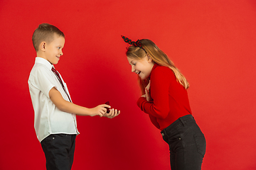 Image showing Valentine\'s day celebration, happy caucasian kids isolated on red background