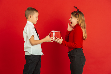 Image showing Valentine\'s day celebration, happy caucasian kids isolated on red background