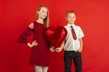 Image showing Valentine\'s day celebration, happy caucasian kids isolated on red background