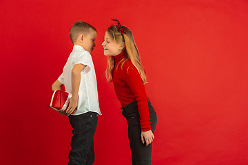 Image showing Valentine\'s day celebration, happy caucasian kids isolated on red background