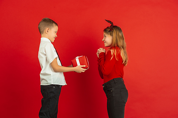 Image showing Valentine\'s day celebration, happy caucasian kids isolated on red background