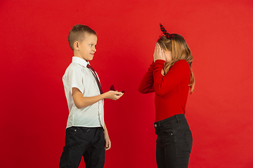 Image showing Valentine\'s day celebration, happy caucasian kids isolated on red background