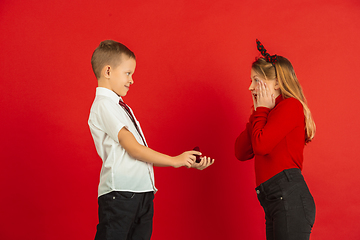 Image showing Valentine\'s day celebration, happy caucasian kids isolated on red background