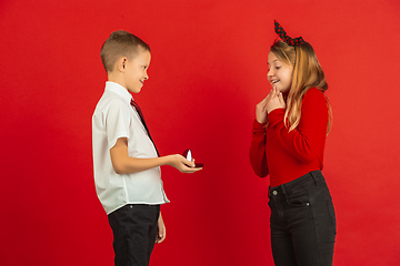 Image showing Valentine\'s day celebration, happy caucasian kids isolated on red background