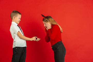 Image showing Valentine\'s day celebration, happy caucasian kids isolated on red background