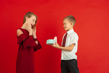 Image showing Valentine\'s day celebration, happy caucasian kids isolated on red background