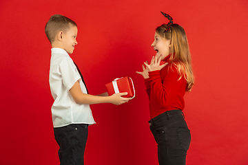 Image showing Valentine\'s day celebration, happy caucasian kids isolated on red background