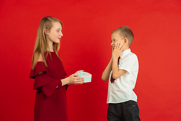 Image showing Valentine\'s day celebration, happy caucasian kids isolated on red background